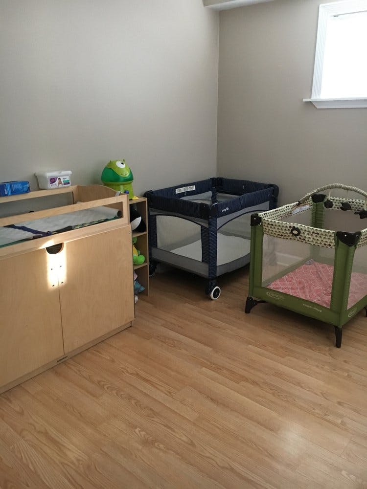 Changing table and two portable cribs in a room