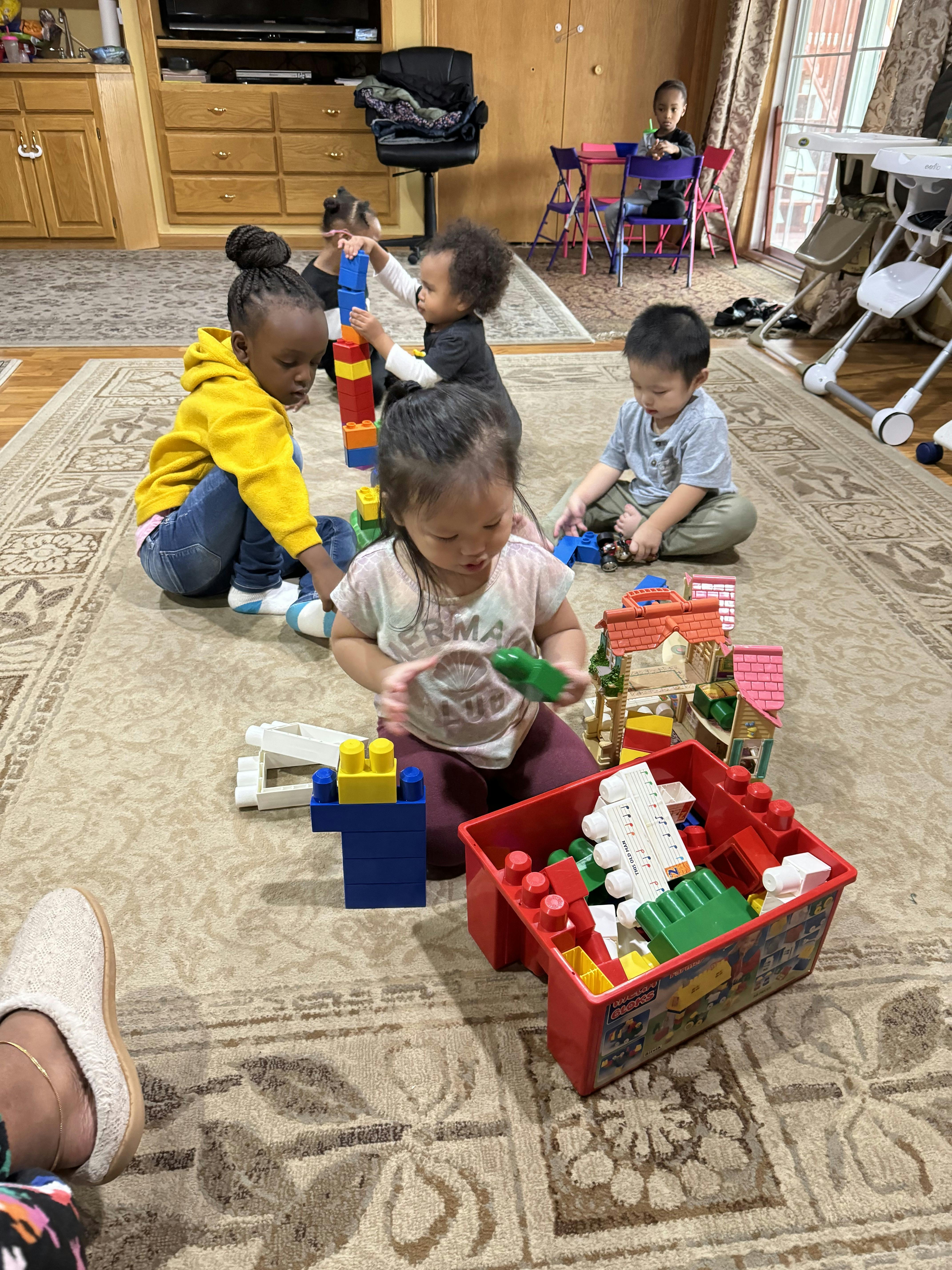 Children playing with building blocks on a rug