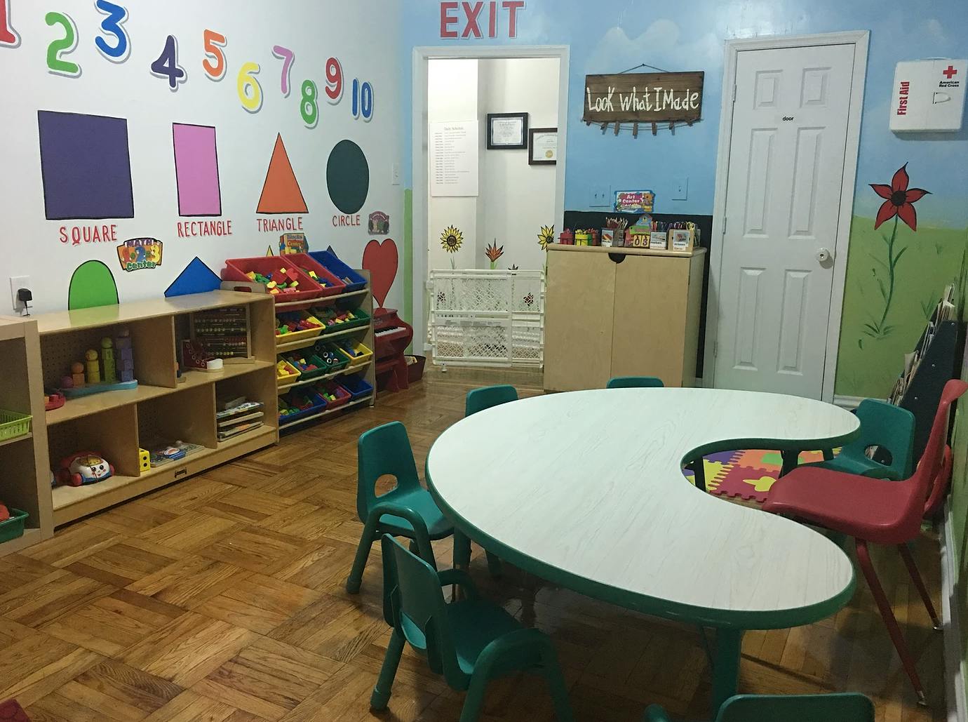 Classroom with a crescent-shaped table and chairs, shelves, and wall decorations