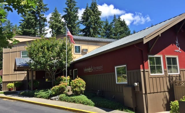 Building with red and brown siding and an American flag on a pole