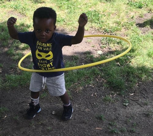 Child with a hula hoop around their waist