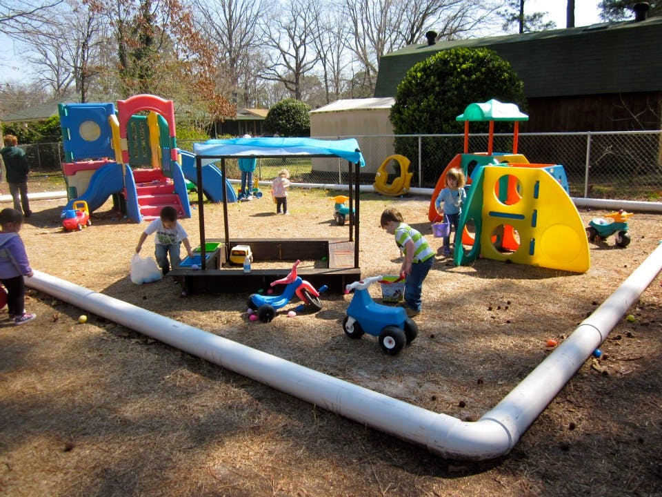 Children playing on a playground with various play structures