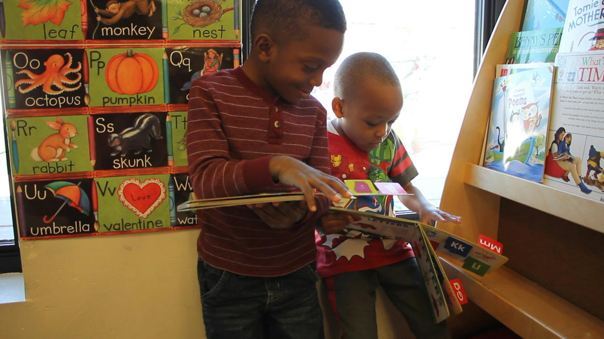 Two children looking at books in a classroom
