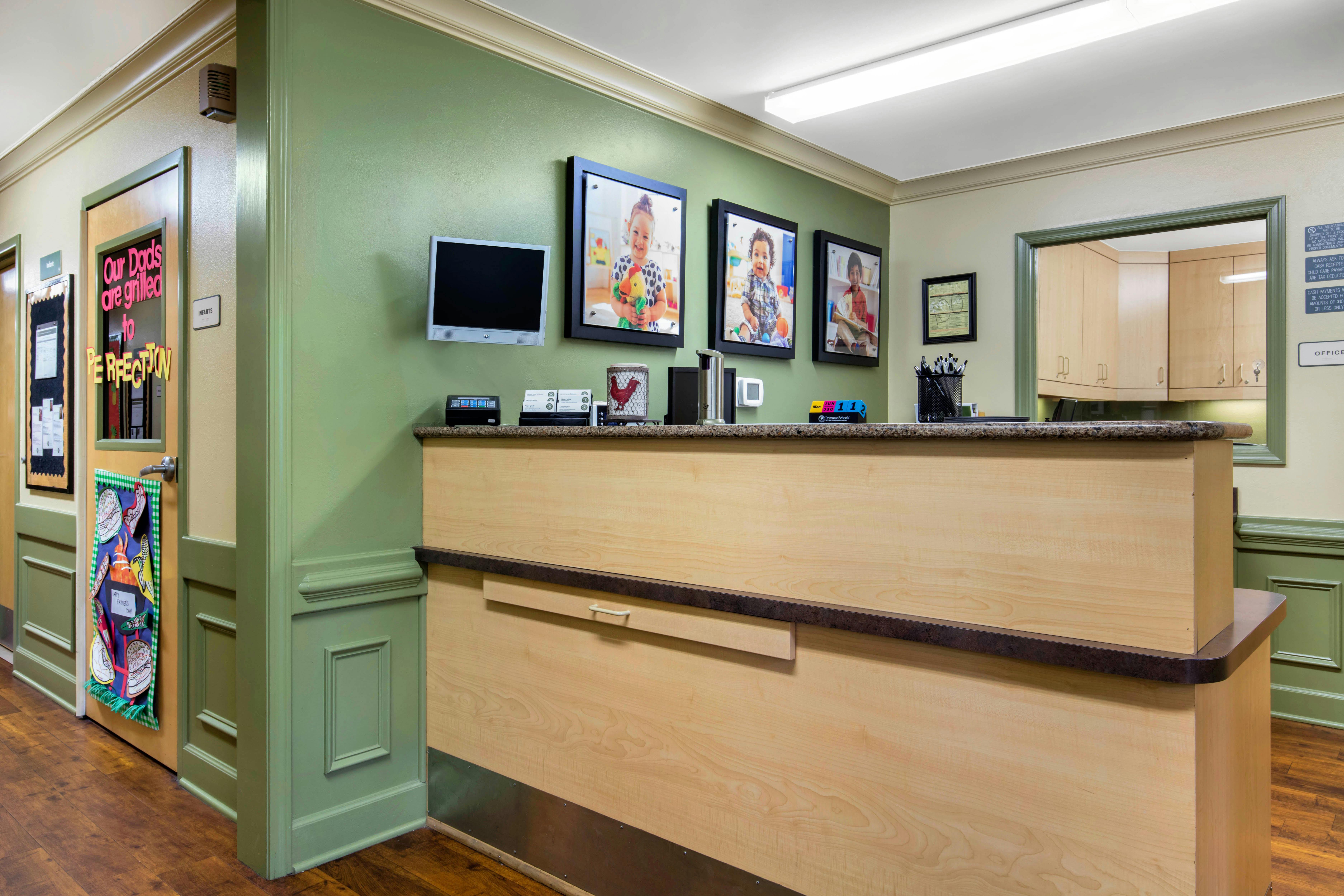 Reception desk with photos of children on the wall