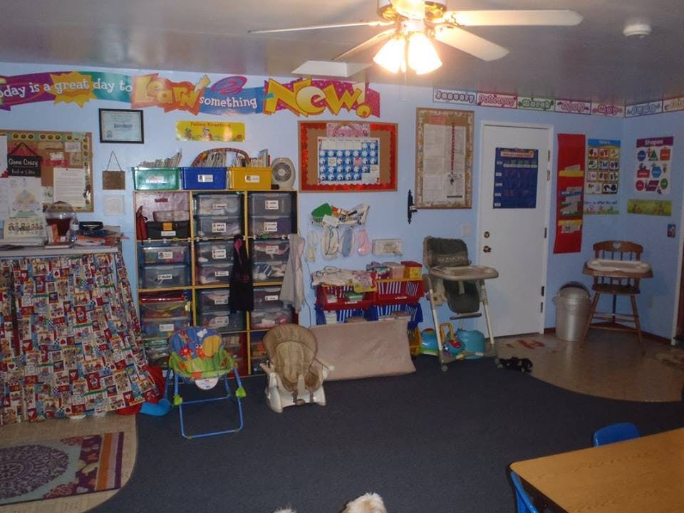 Room with various items, including shelves, a high chair, and wall decorations