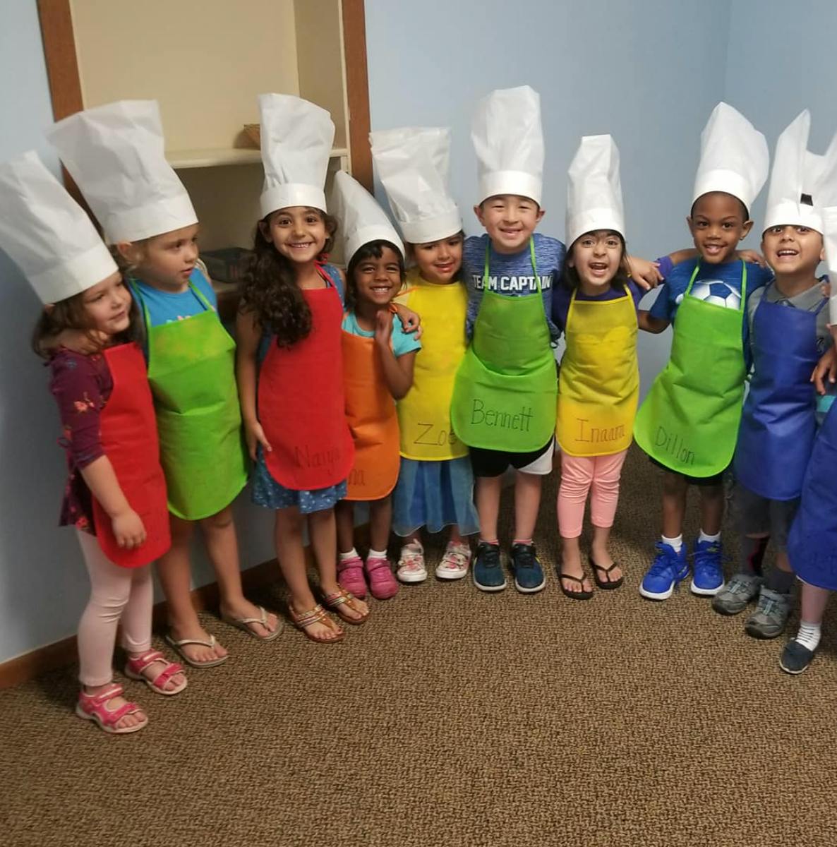 Group of children wearing chef hats and aprons