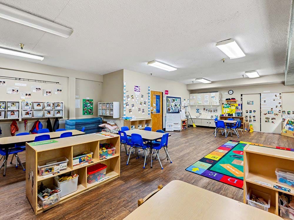Empty colorful children's classroom with small tables and chairs