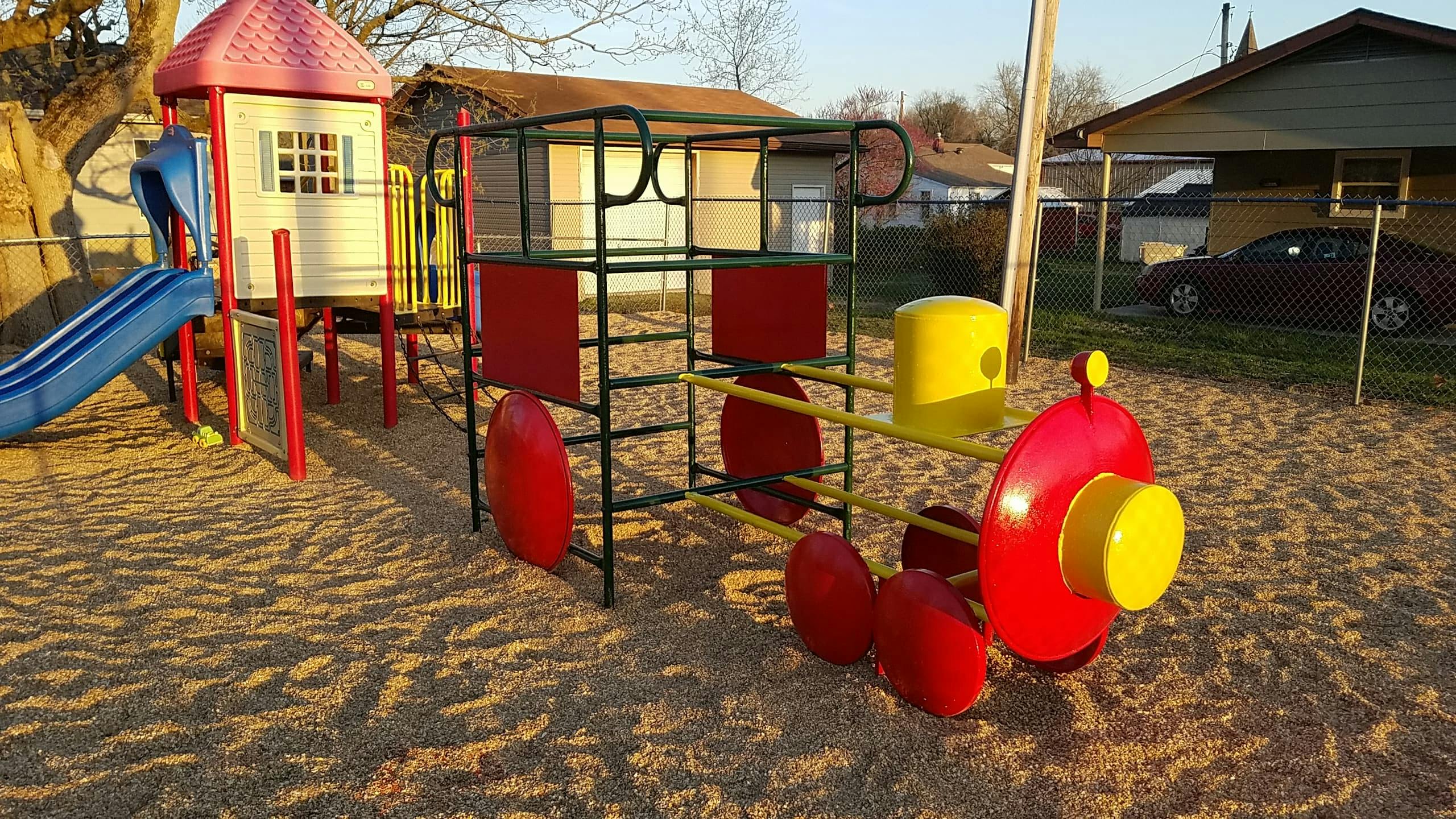Playground with a slide and a train-shaped climbing structure