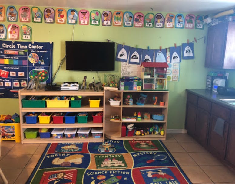 Classroom with shelves of toys, a TV, and a colorful rug