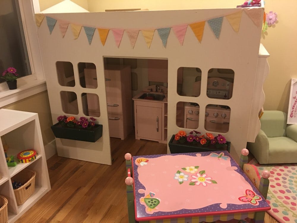 Playhouse with a pink table and chairs in-built kitchen
