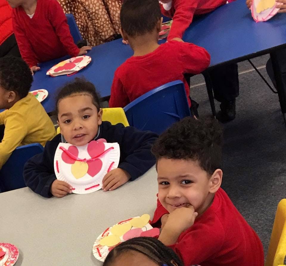Children at tables with paper plate crafts