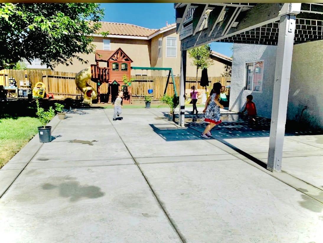 People walking on a patio with a playground in the background