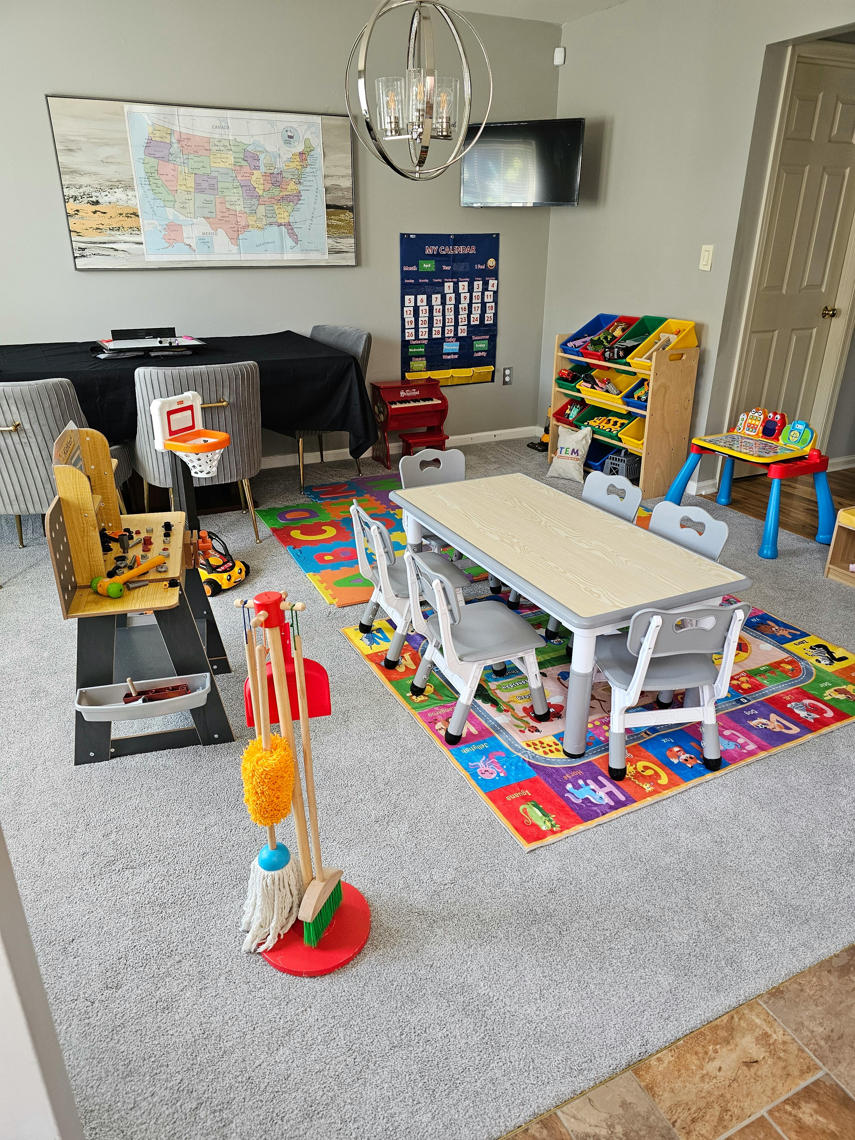 Playroom with children's table, chairs, learning rug, and toy sets
