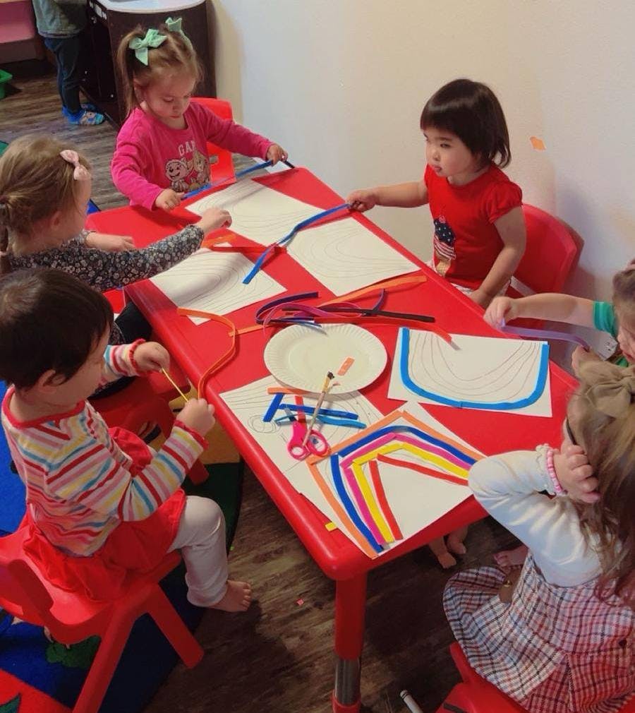 Children sitting at a table doing crafts