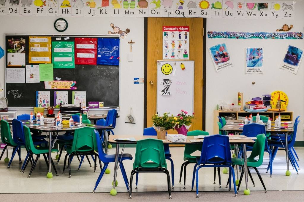 Classroom with tables and chairs, alphabet on wall