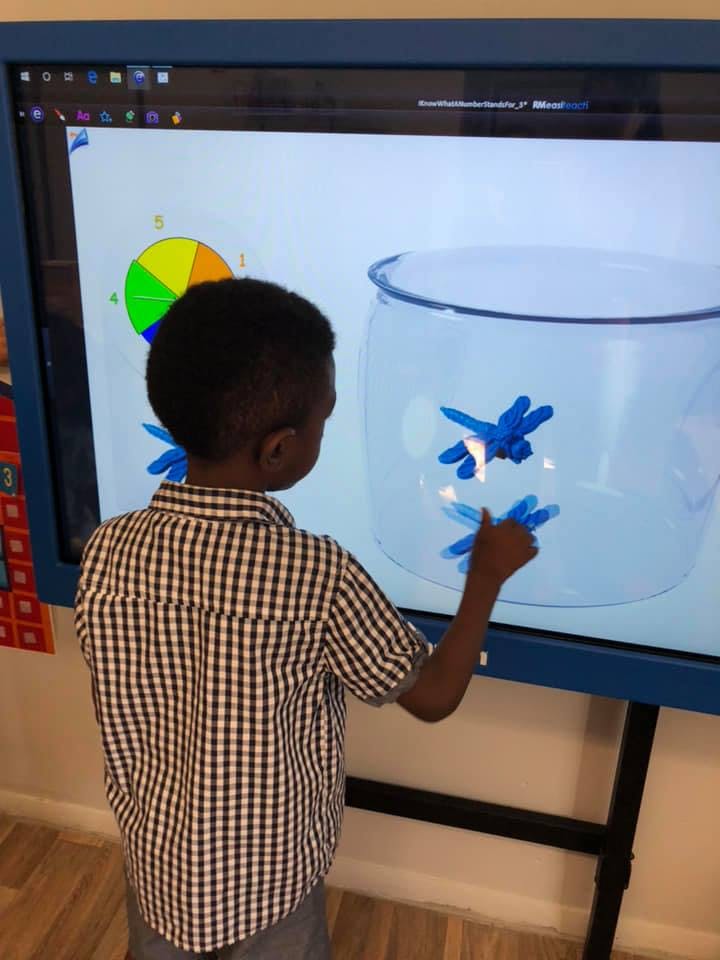 Child interacting with a large touchscreen display