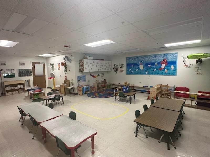 Empty classroom with small tables and chairs