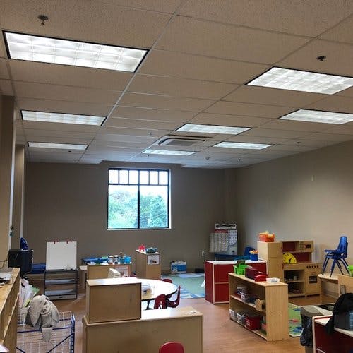 Empty classroom with tables, chairs, and shelves