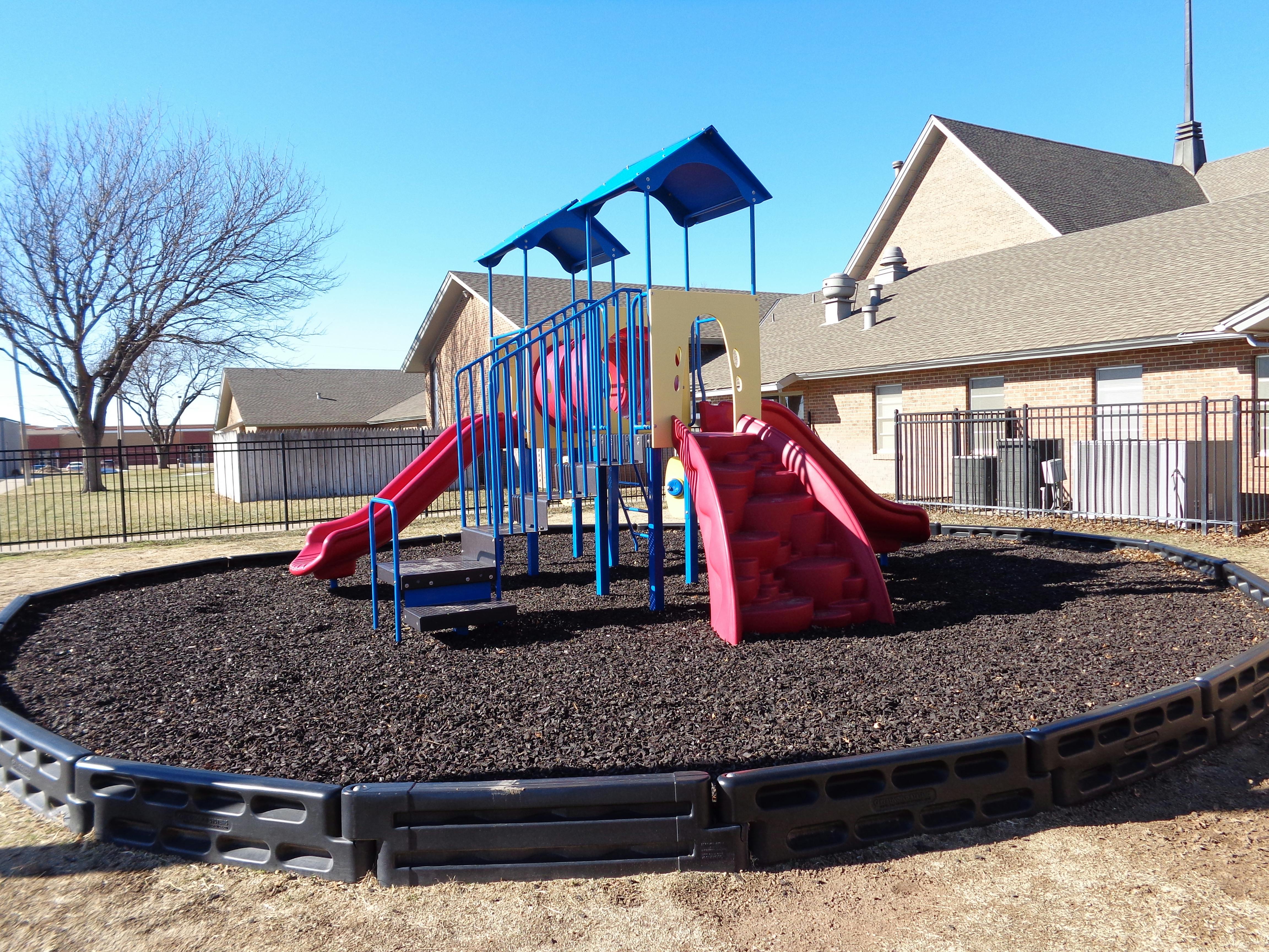 Playground with slides and climbing structure on wood chips