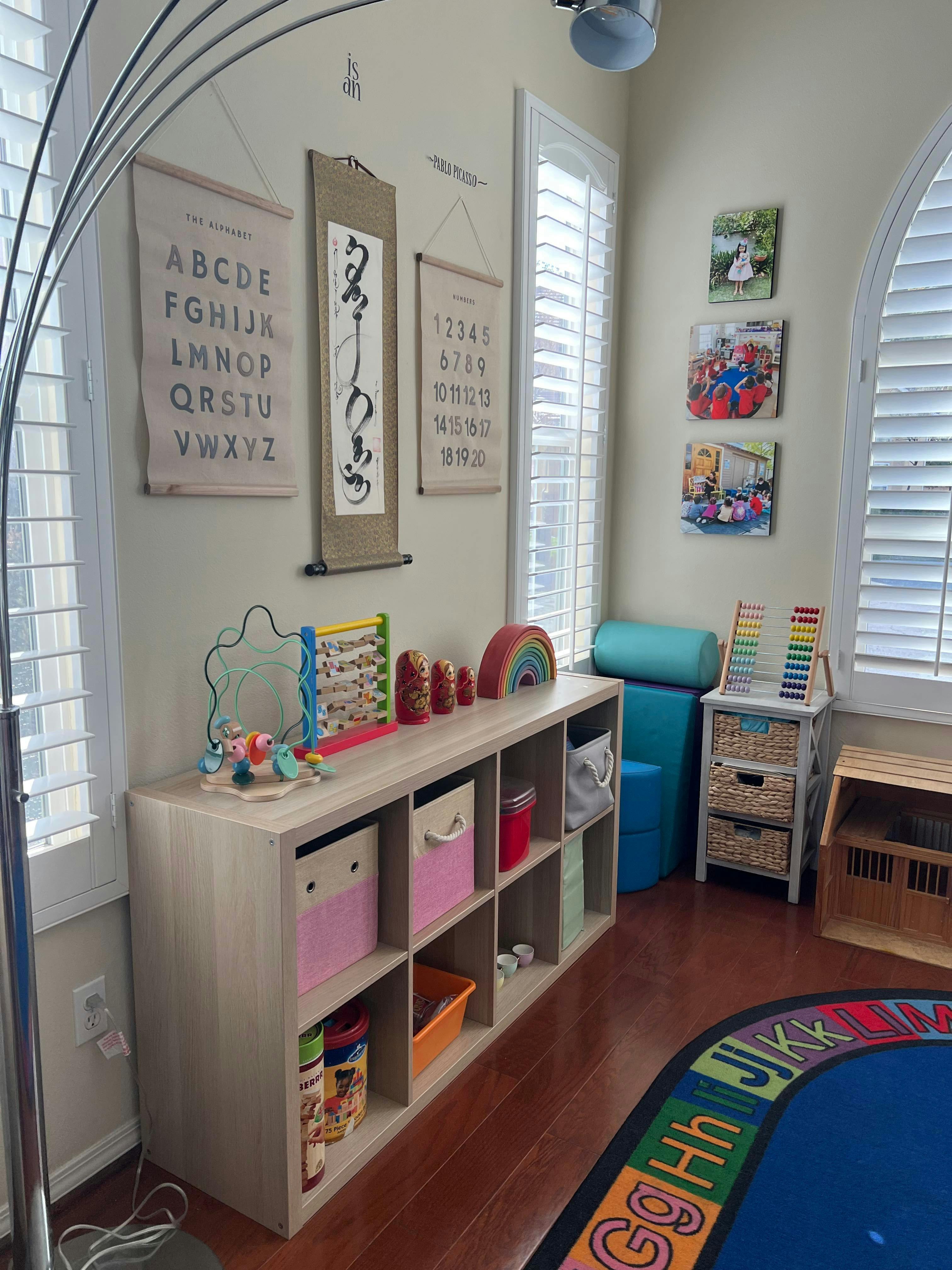 Playroom with storage shelves, toys, and alphabet rug