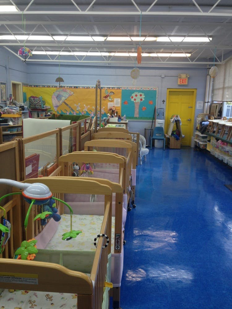 Rows of empty cribs in a daycare room