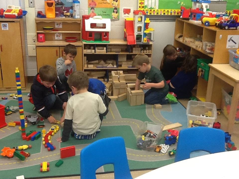Children playing with blocks and toys in a classroom
