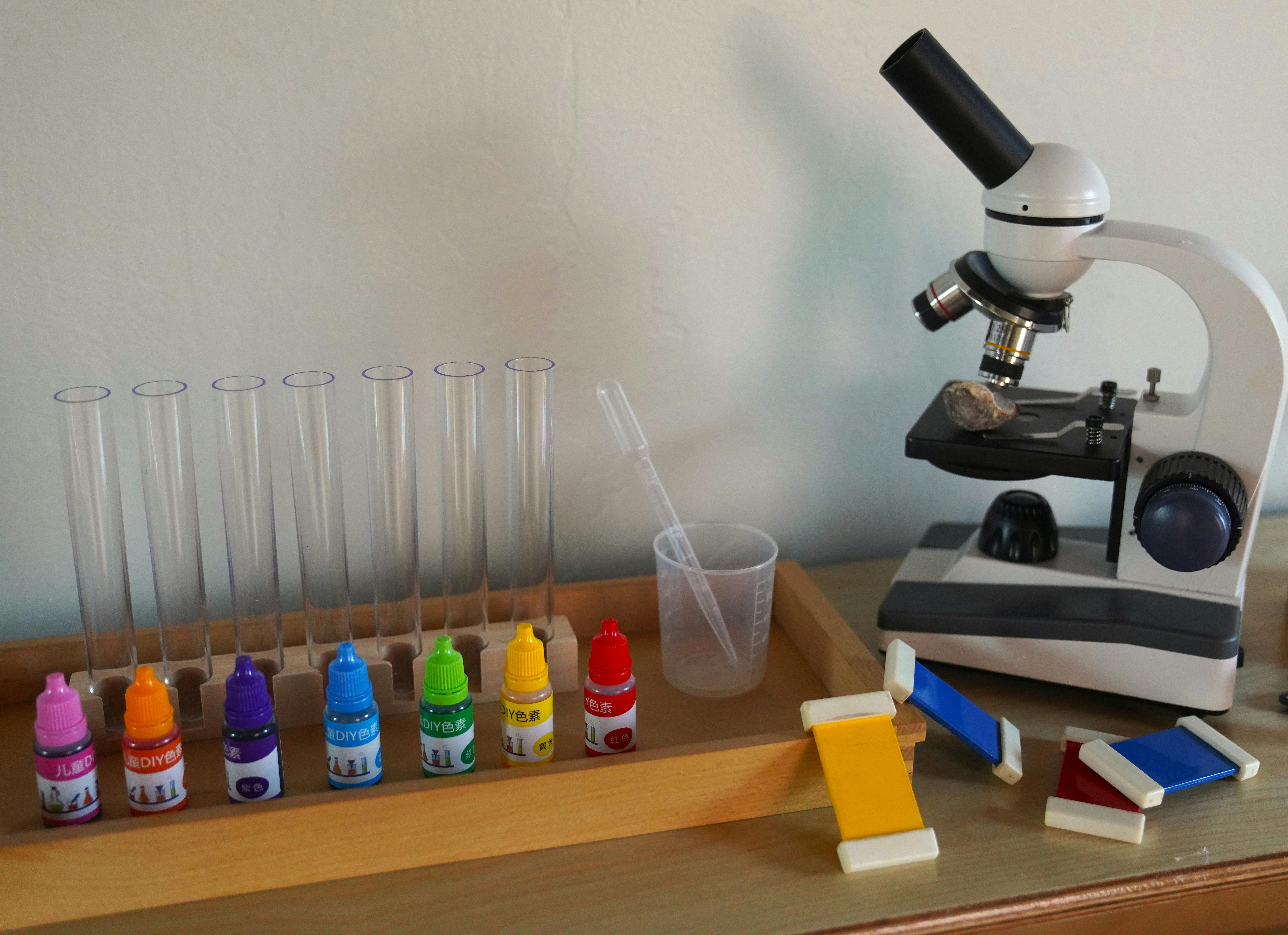 Microscope, test tubes, and colorful bottles on a table