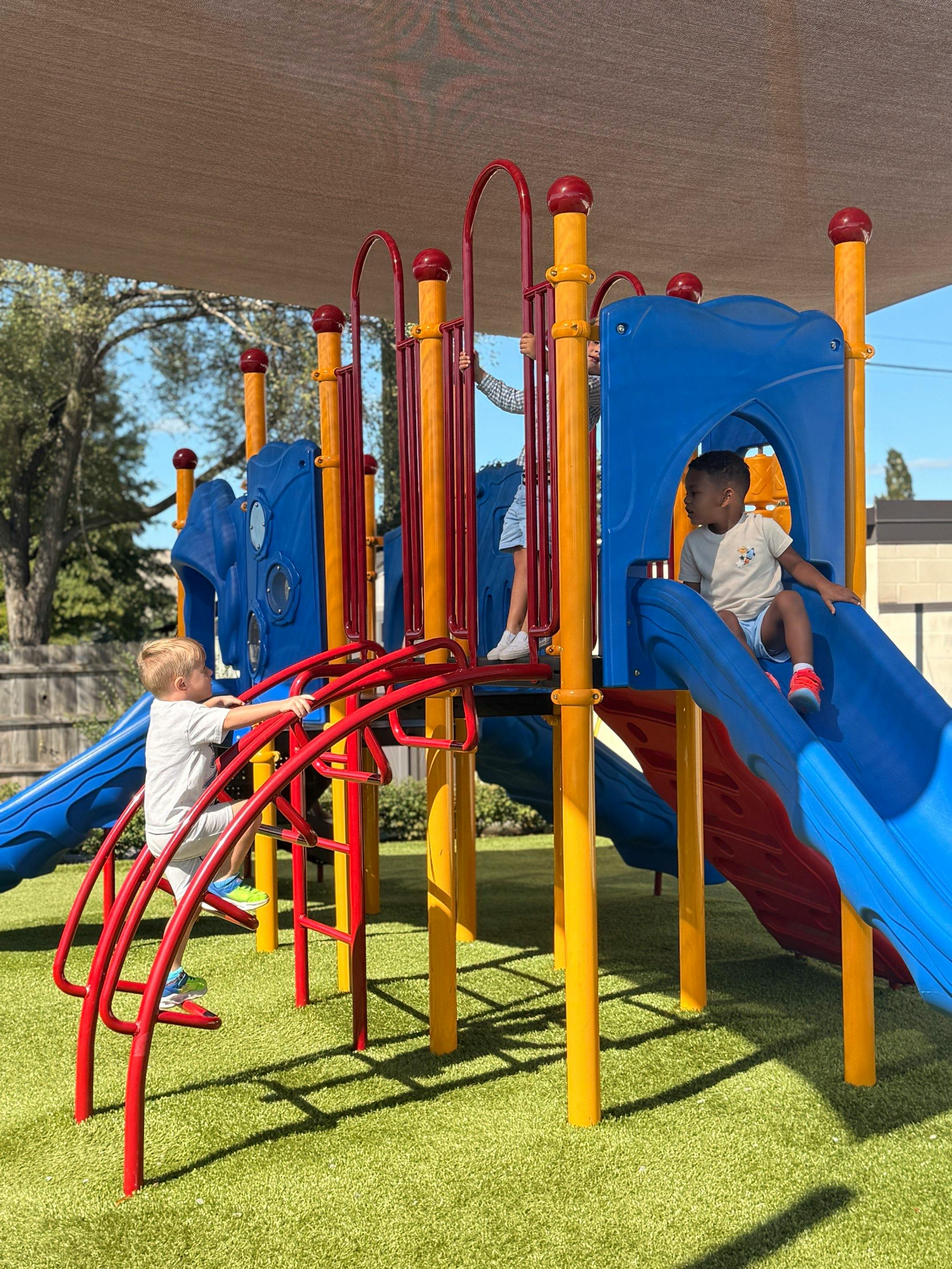 Two children playing on a playground structure