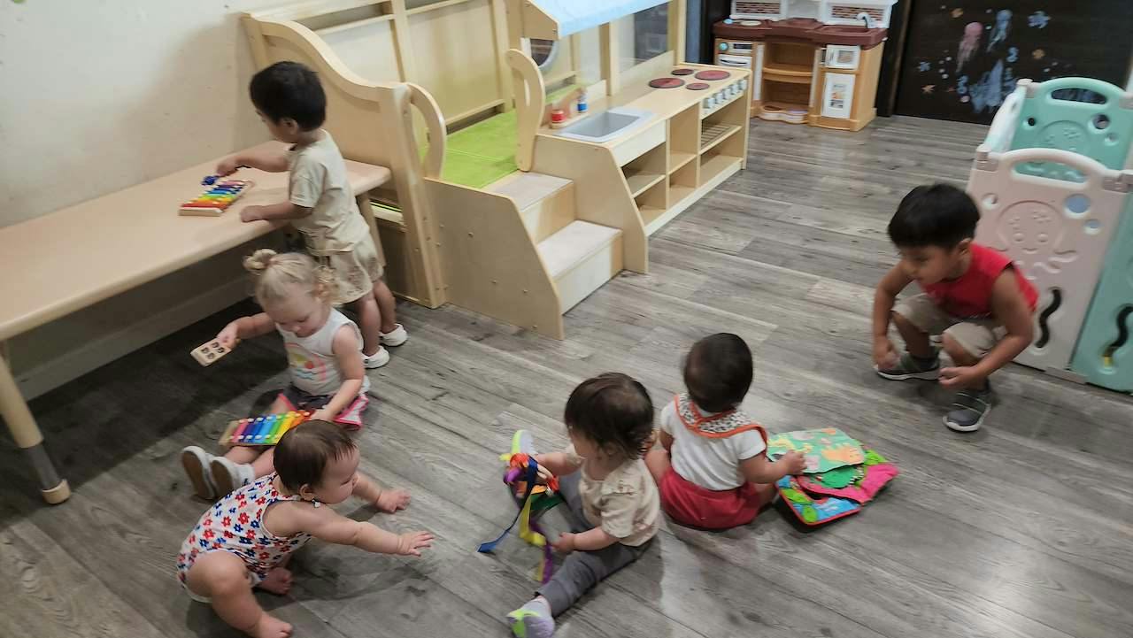 Group of young children playing with toys on the floor of a daycare