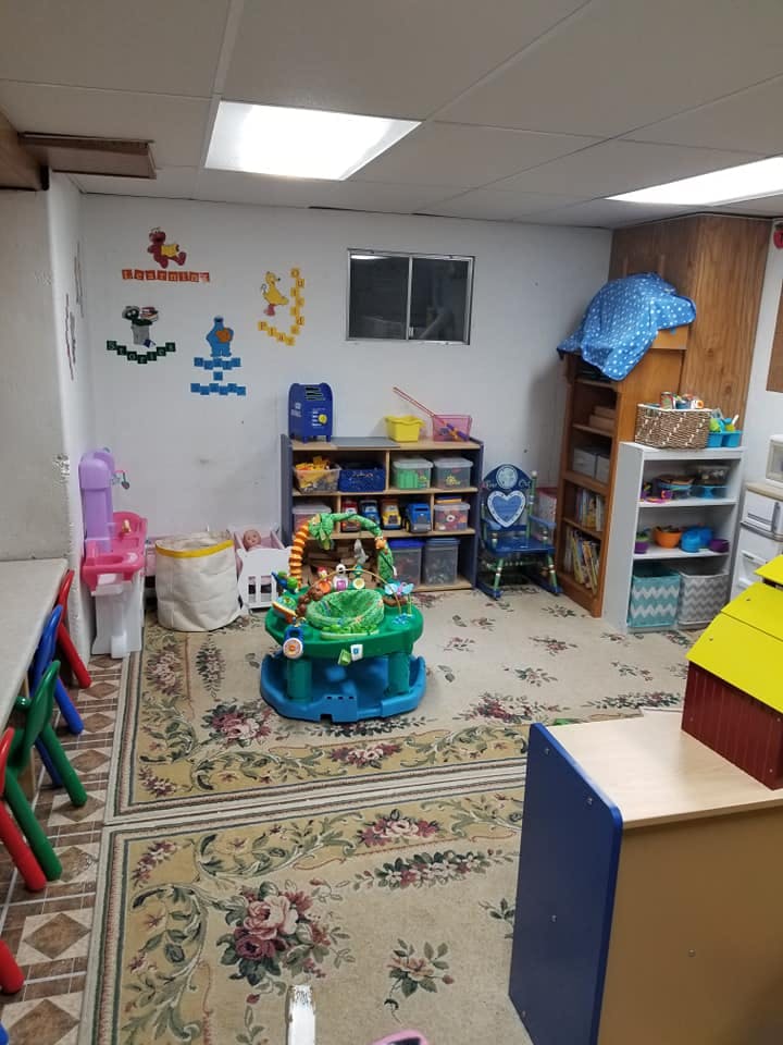 Playroom with toys, shelves, and a patterned rug