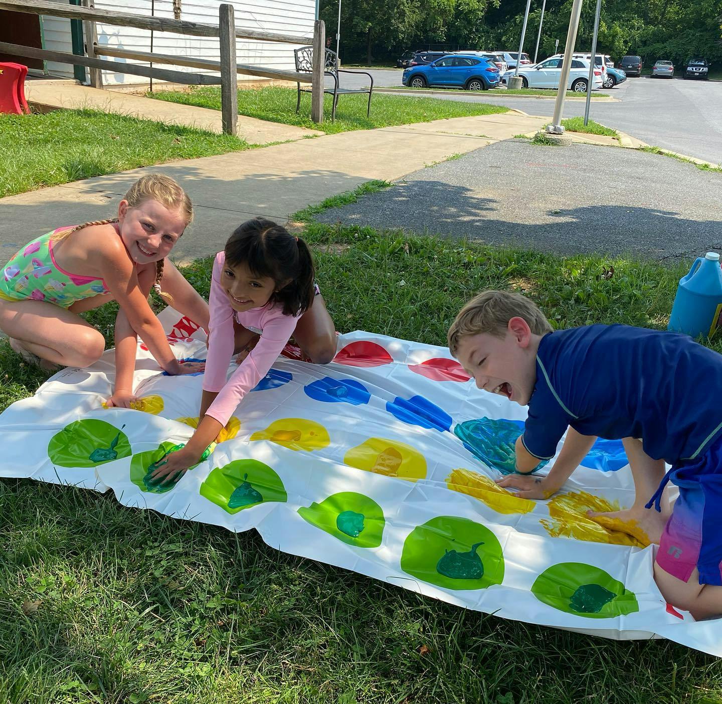 Three children playing Twister on a lawn