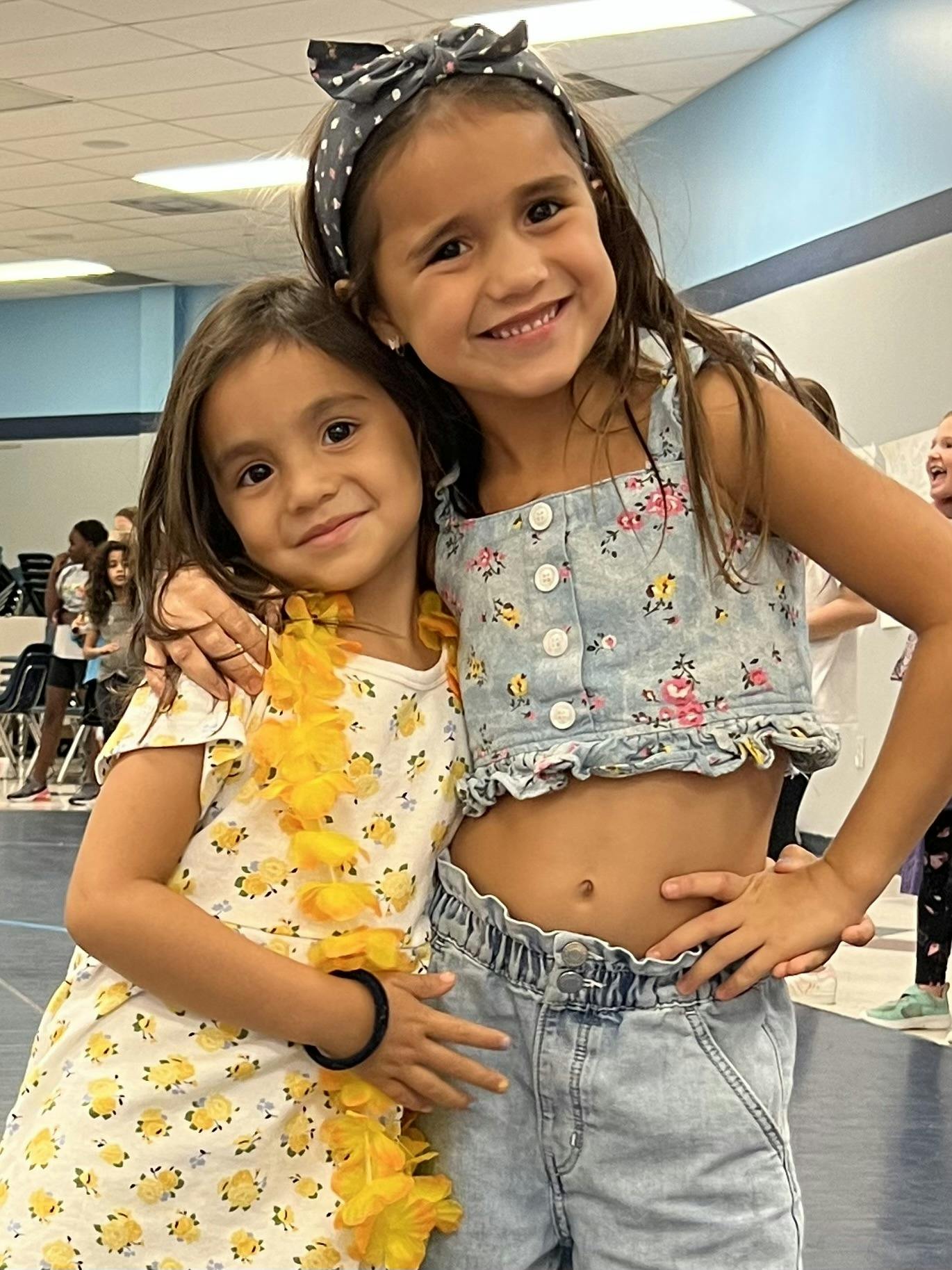 Two smiling children with their arms around each other