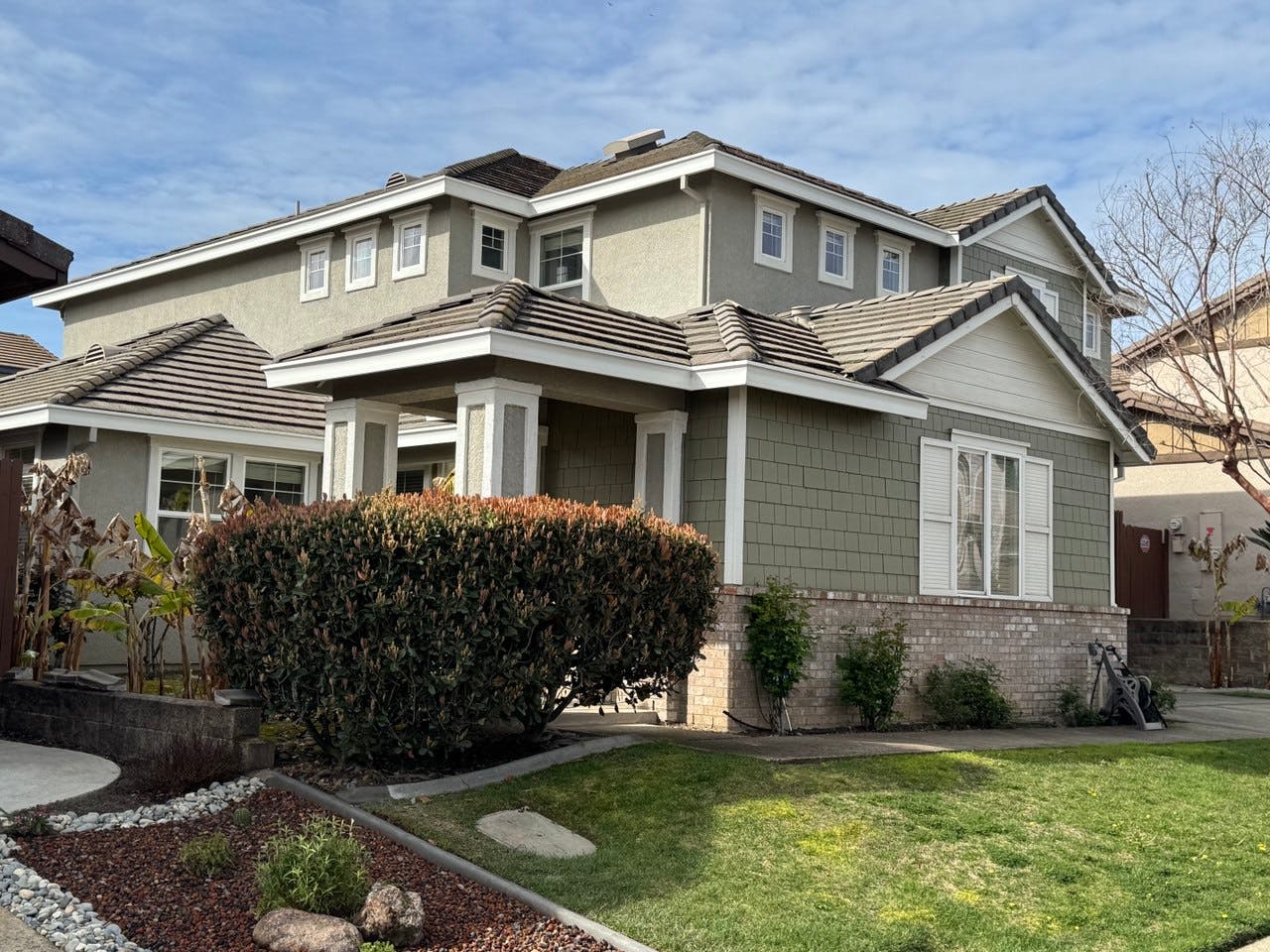 Two-story house with green siding and a front lawn