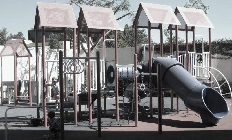 Child on a playground structure with a slide
