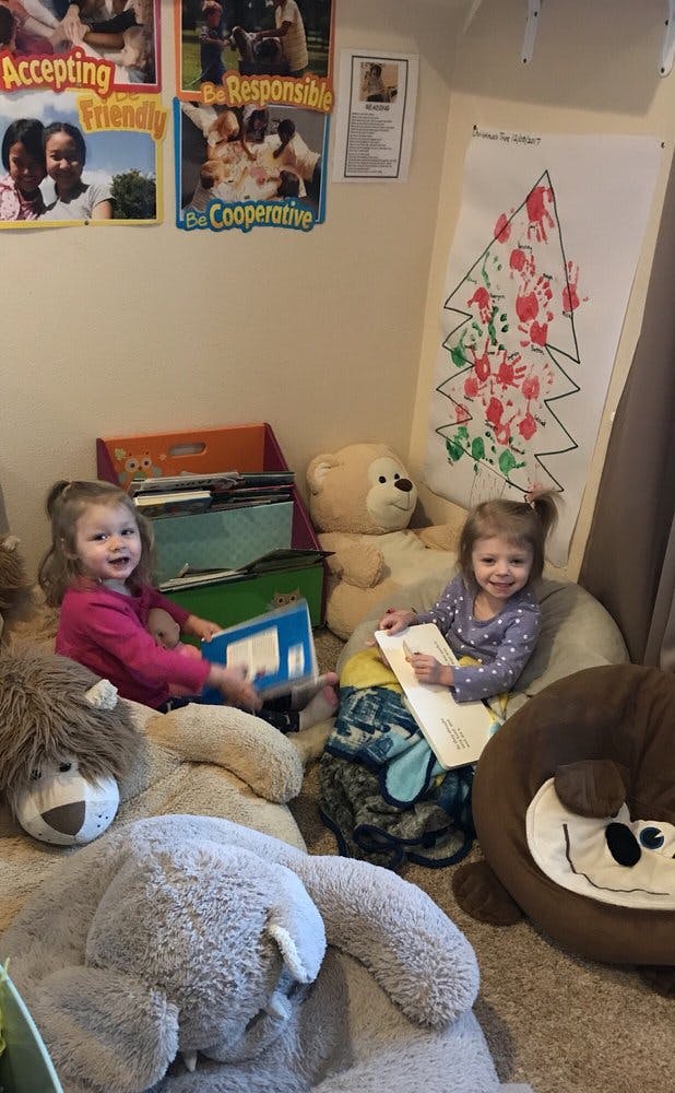 Two children sitting on large stuffed animals, holding books