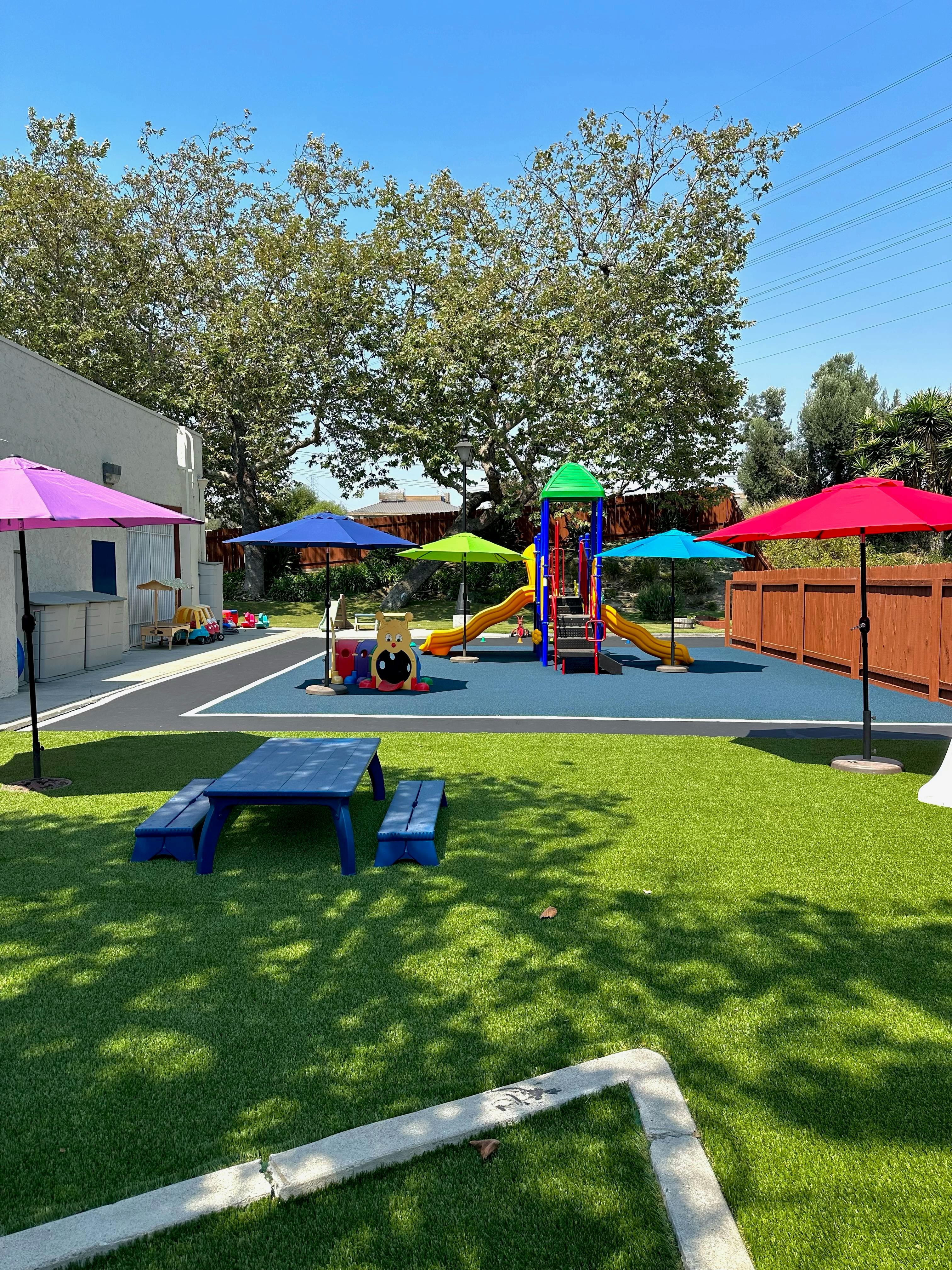 Outdoor playground with slides, swings, and picnic tables