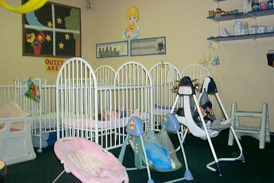 Nursery room with multiple cribs and baby swings