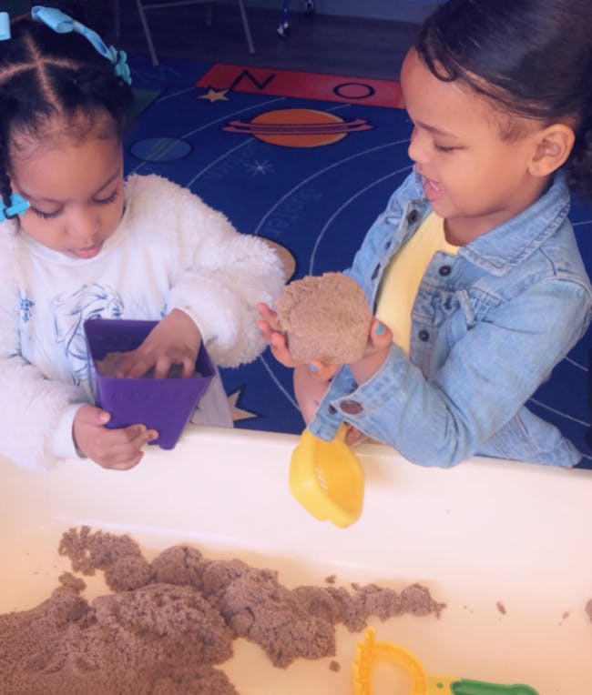 Two children playing with kinetic sand