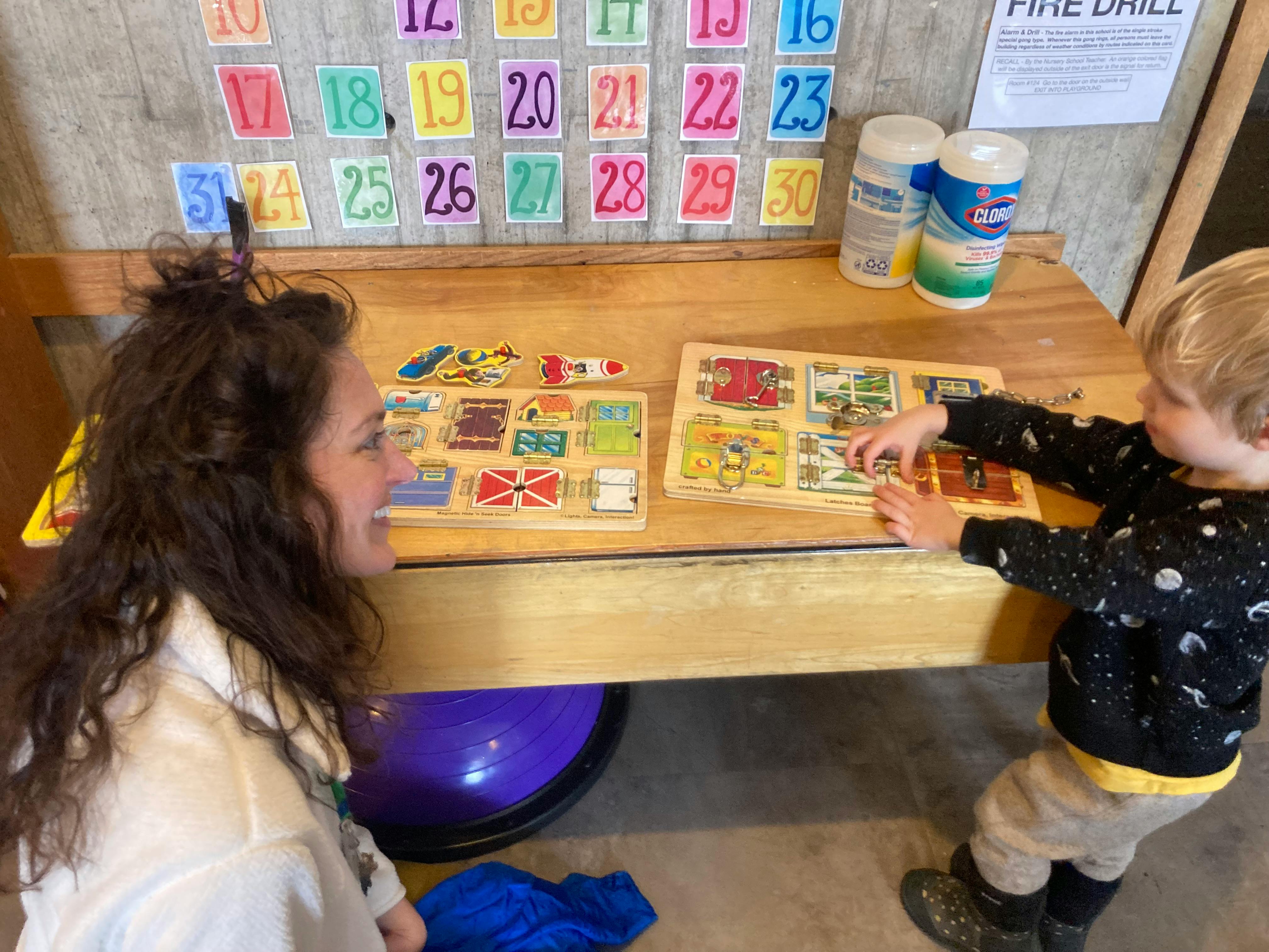 Person and child playing with puzzles at a table