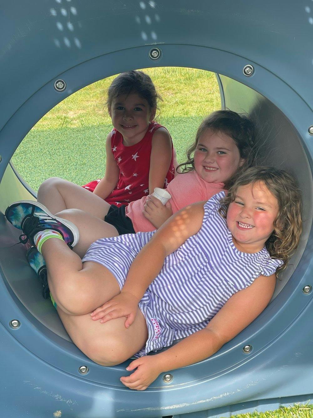 Three children in a playground tunnel