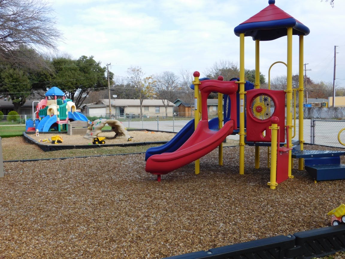 Playground with red and blue slides and play structures