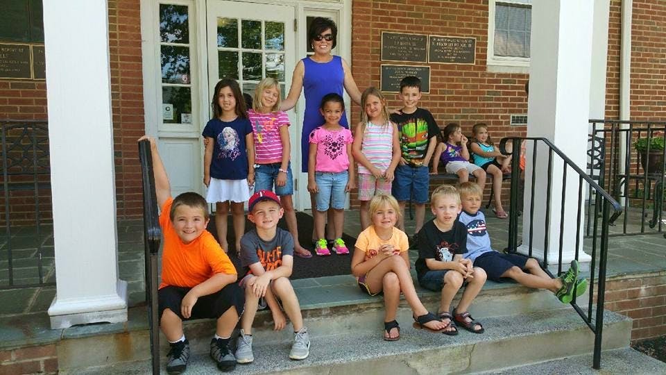 Adult and multiple children posing on steps