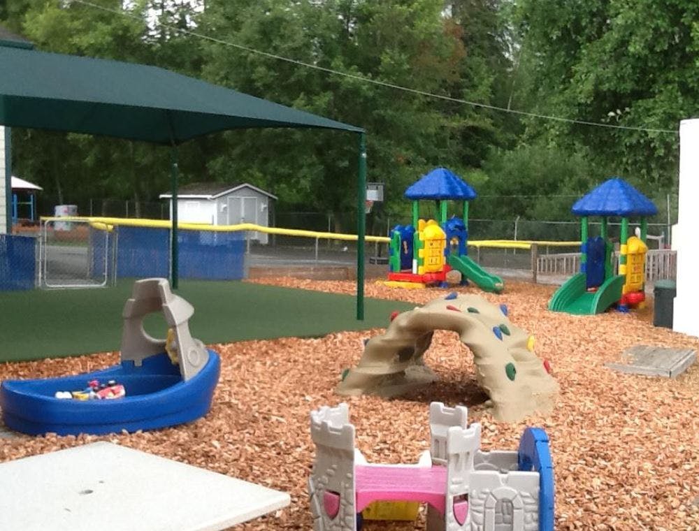 Outdoor playground with slides, climbing structure, and shaded area
