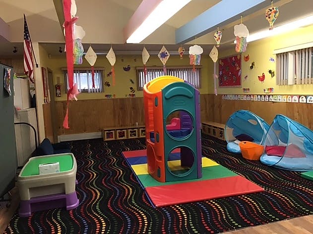 Indoor play area with colorful play structure and blue tents