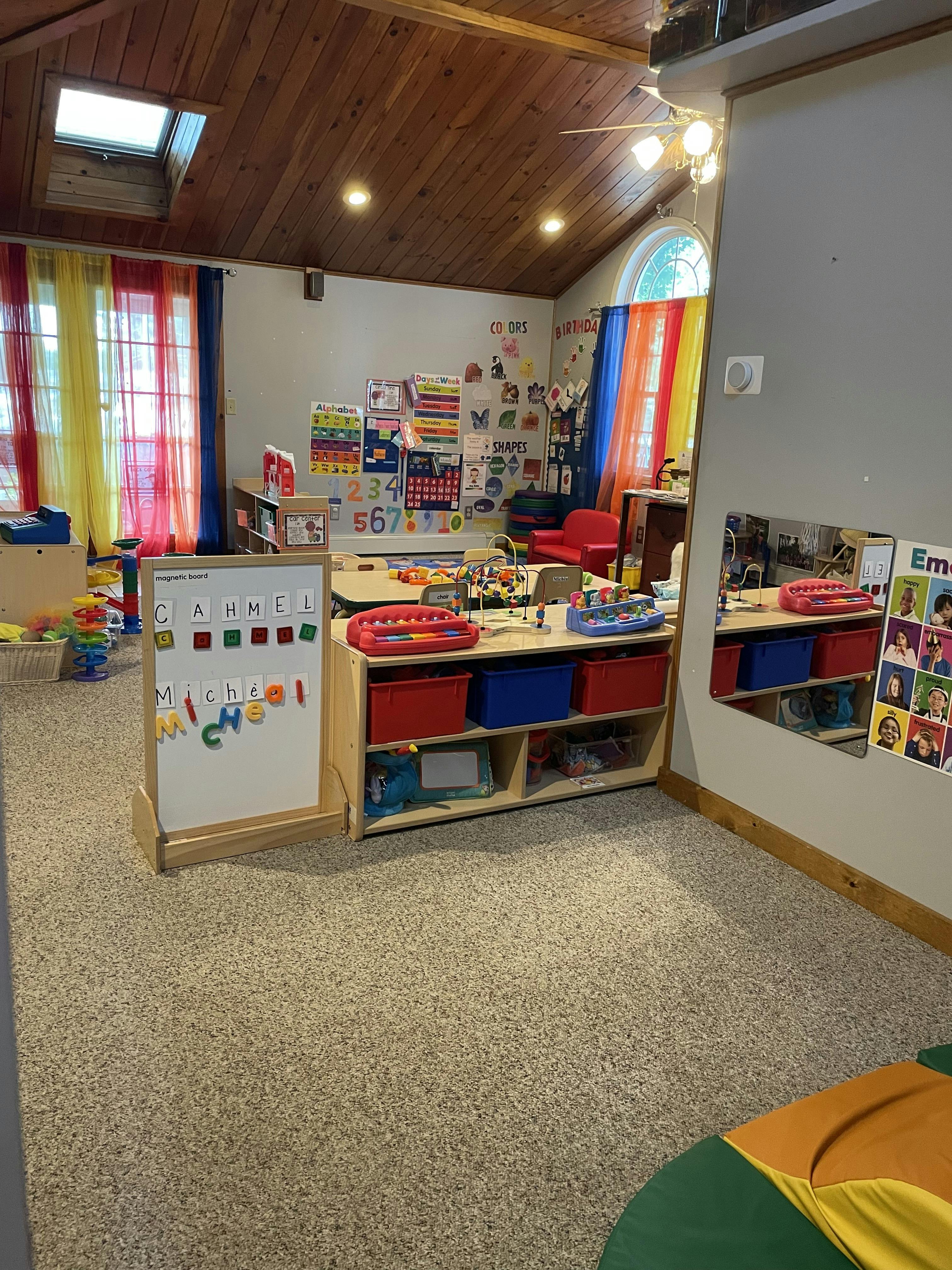 Classroom interior with educational toys, magnetic board, and wall charts