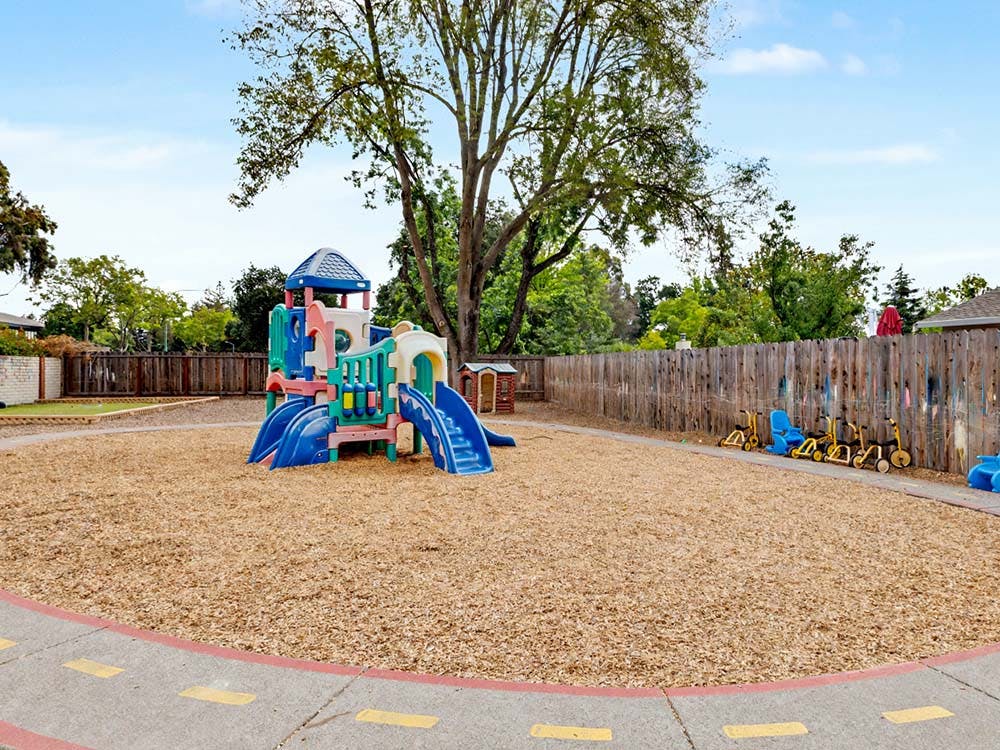 Colorful playground structure on wood chips in an outdoor play area
