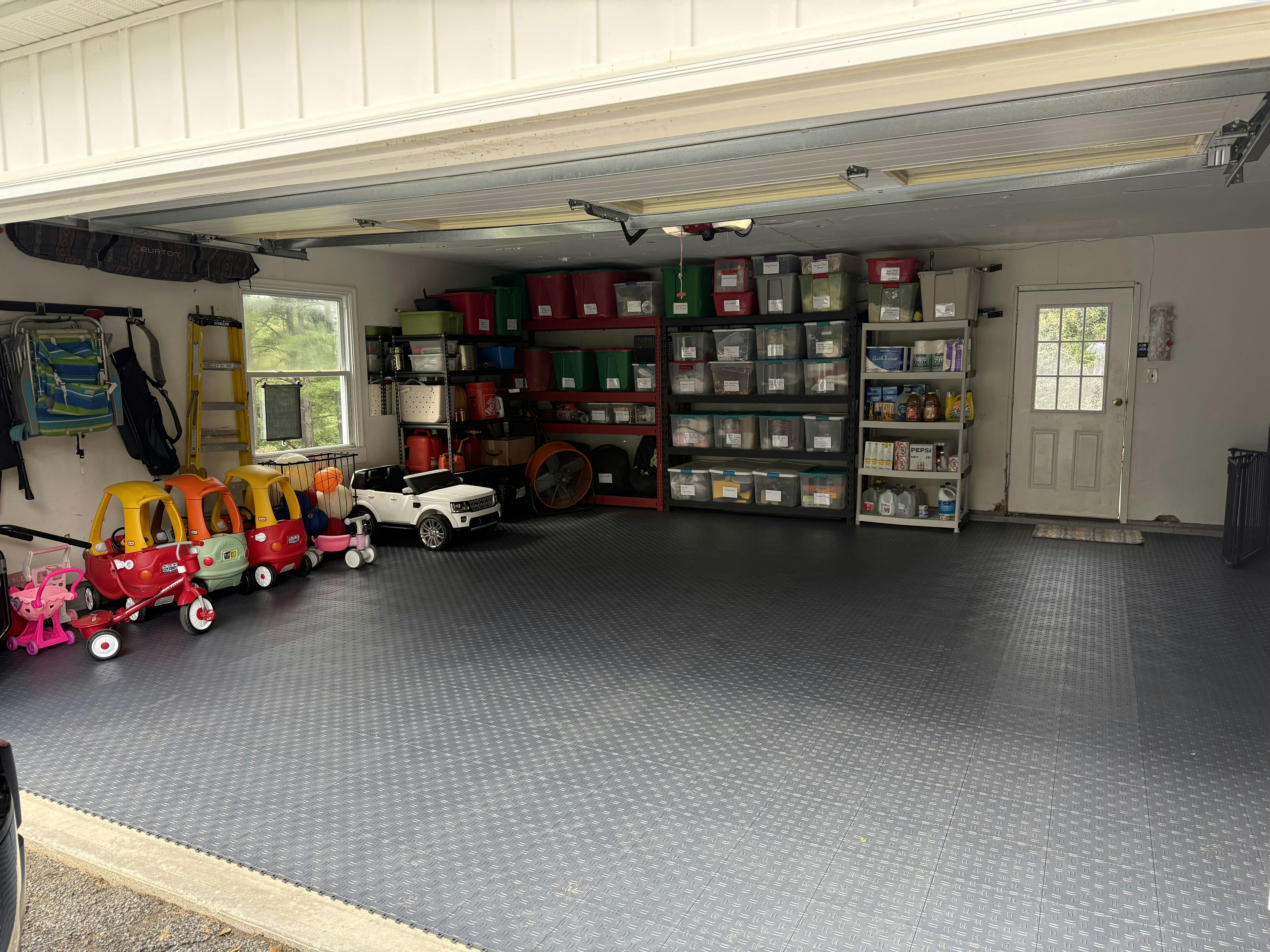 Organized garage with shelving units and ride-on toy vehicles