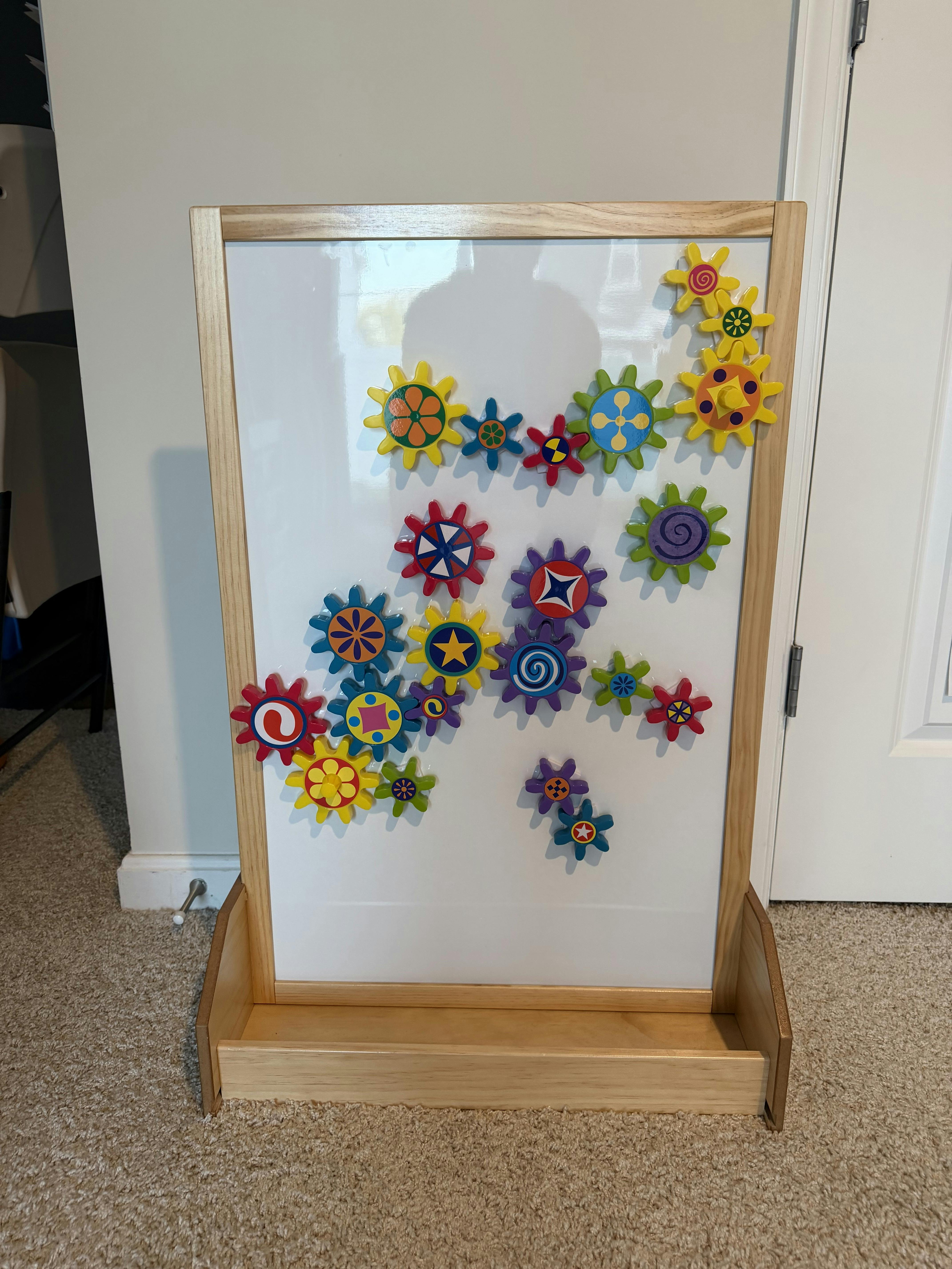 Colorful magnetic gear toys arranged on a white board