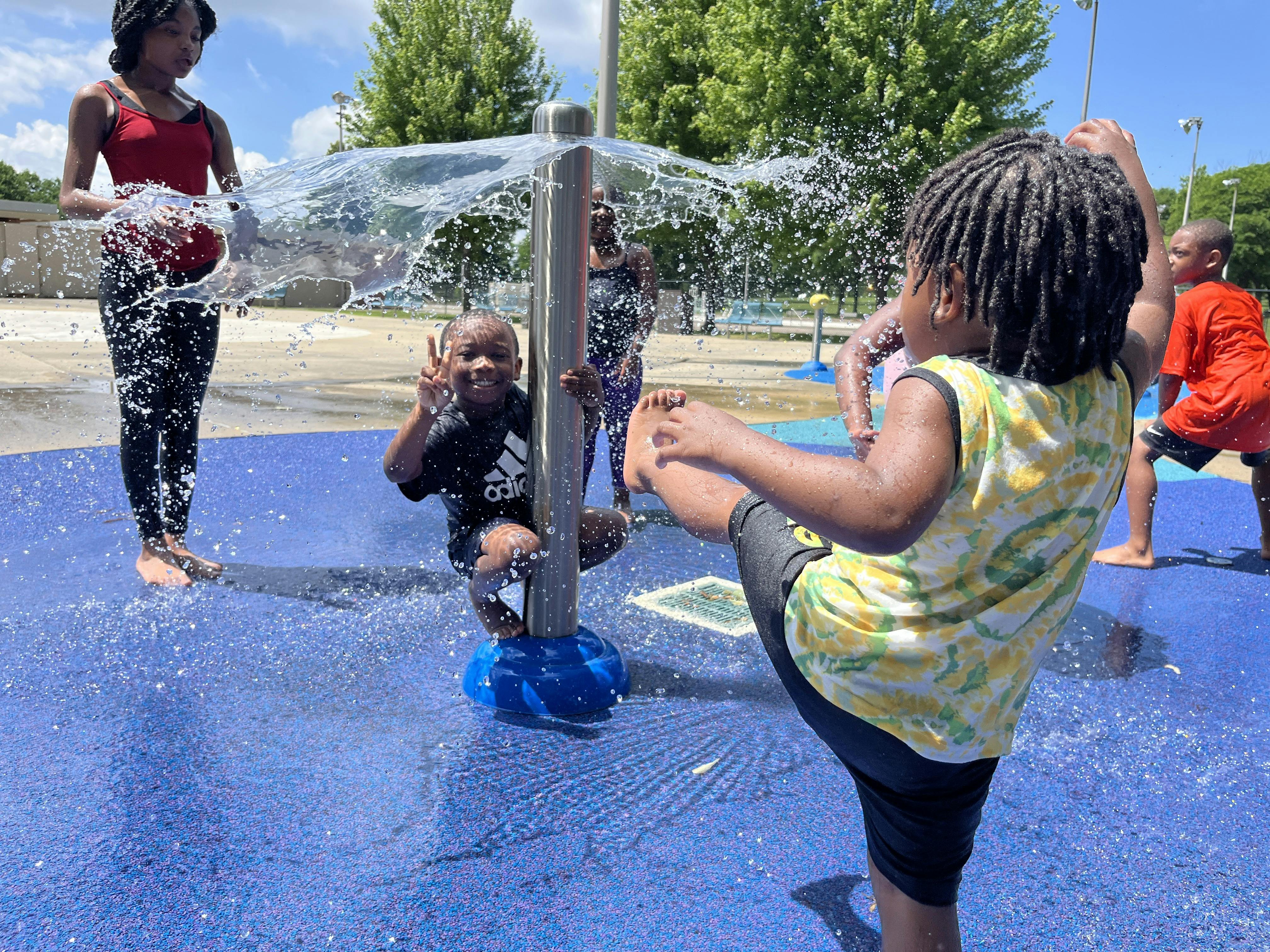 Children playing in a splash pad with water spraying