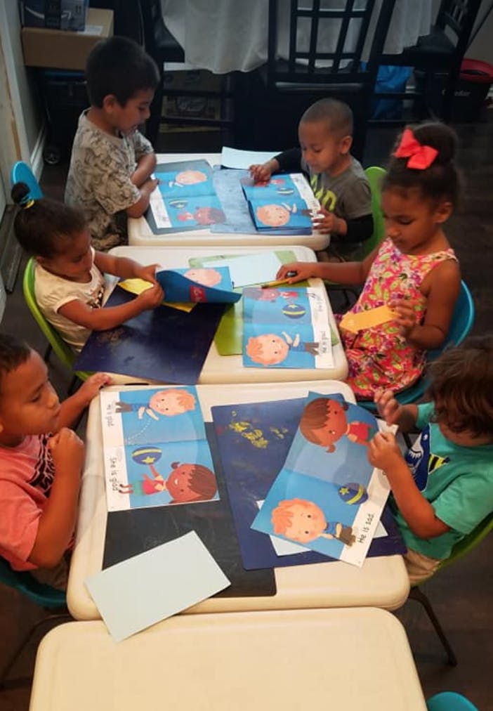 Children sitting at tables with papers and books